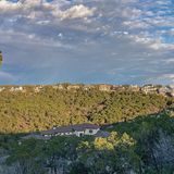 Photo of a landscape with lush greenery on the bottom and blue sky on the top.