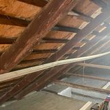 A photo inside the attic looking at the roof framing