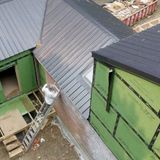 Birds eye view of contractor working above the new metal roof