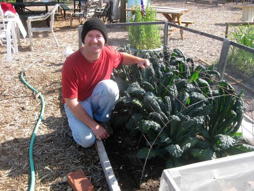 author in front of kale crop