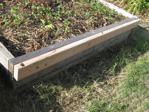 The 2x4 wood stud attached to the side of the bed.