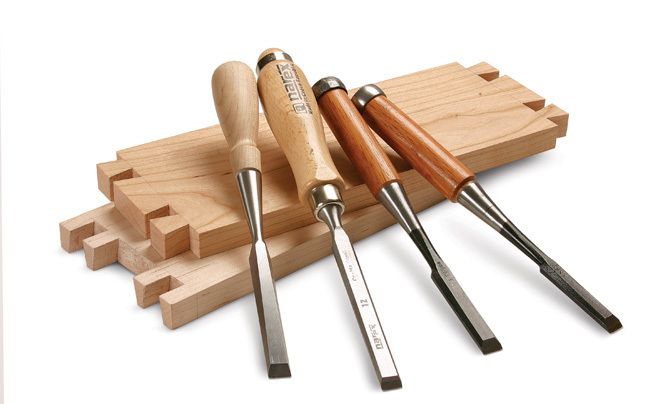 Old and well used wood carving chisels, on a old workbench. Stock Photo