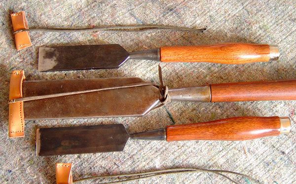 Old and well used wood carving chisels, on a old workbench. Stock Photo