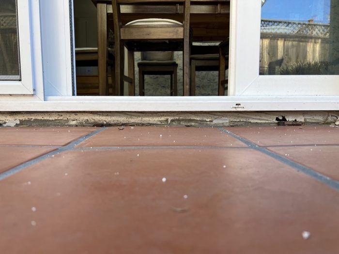 The French patio door installed at my house was too small for the rough  opening, so there is a gap between the concrete slab and threshold of about  1.5”. What is the