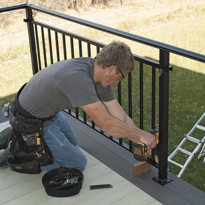16. Measure and install the balustrade. Cut each perimeter balustrade to size, slip it up into the post brackets, and fasten it.